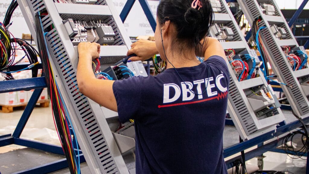 Funcionária montando os Painéis Elétricos da DBTEC.