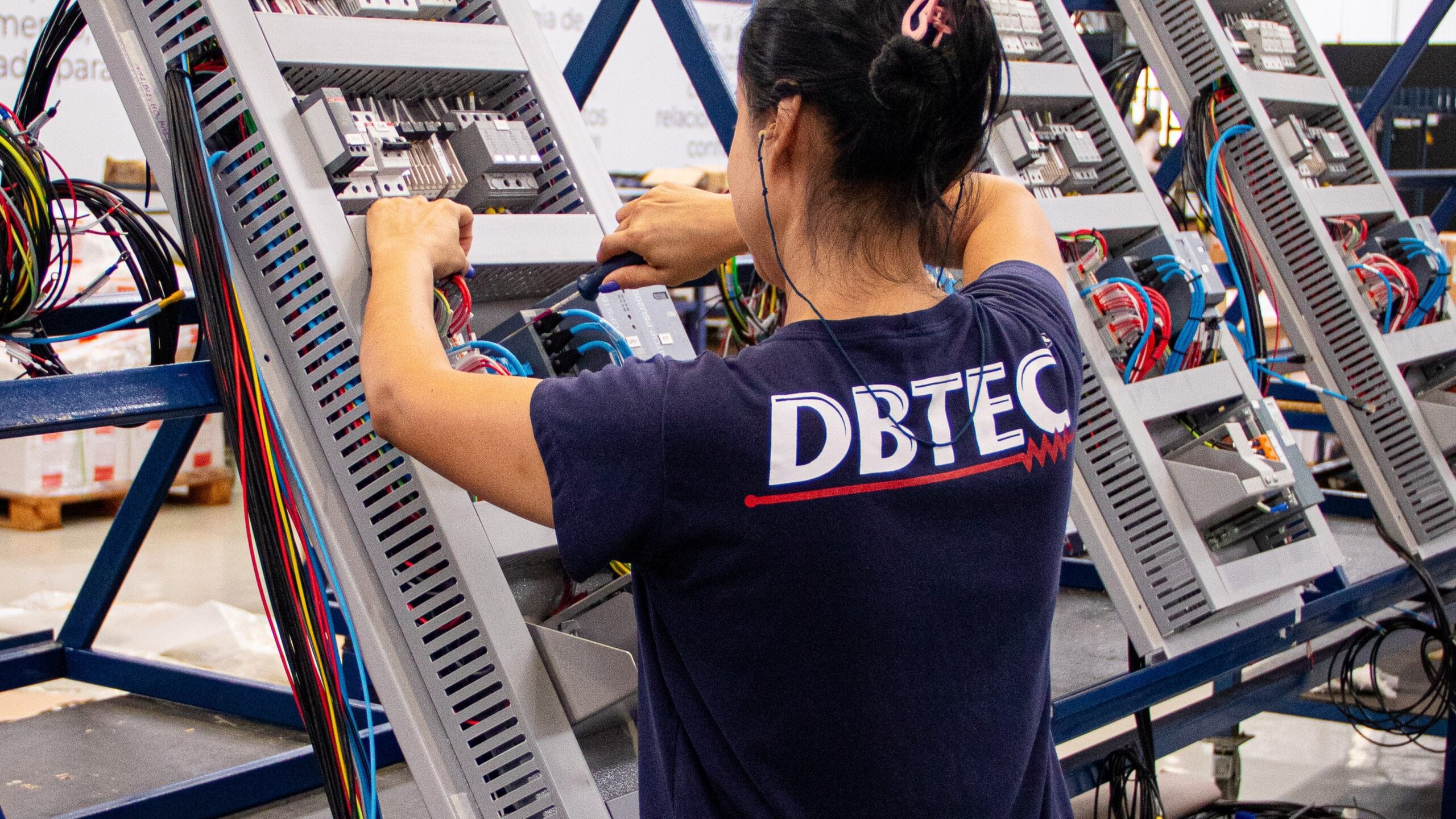Funcionária montando os Painéis Elétricos da DBTEC.