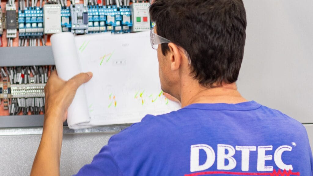 Trabalhador da DBTEC inspecionando um Painel Elétrico.